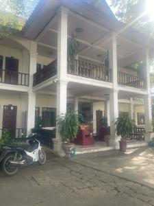 a motorcycle parked in front of a building at Dokban Hotel in Luang Prabang