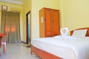 a bedroom with a white bed with a swan on it at Dokban Hotel in Luang Prabang +8 photos