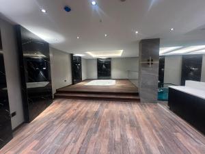 ein großes Zimmer mit Badewanne und Holzboden in der Unterkunft Vela Blu Hotel in Degirmen