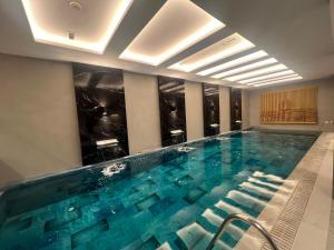 ein Swimmingpool mit blauem Wasser in einem Hotelzimmer in der Unterkunft Vela Blu Hotel in Degirmen