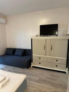 a living room with a blue couch and a tv at Wellness hotel Velky Meder in Veľký Meder