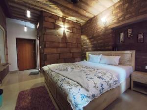 a bedroom with a large bed in a stone wall at Gopal Home Stay & Guest House in Jodhpur +31 photos