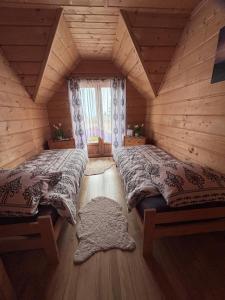 a bedroom with two beds in a log cabin at Gościniec Dziubasowki in Nowy Targ