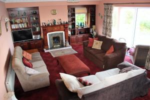 a living room with two couches and a fireplace at Kilsallagh Cottage in Westport