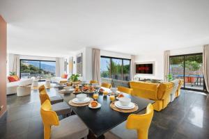 a living room with a table and yellow chairs at Villa Romy, a World apart in Roquebrune-Cap-Martin