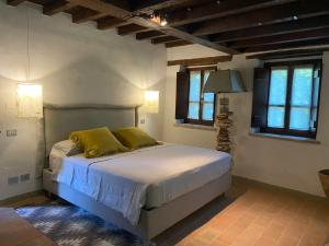 a bedroom with a large bed with yellow pillows at Borgo Vercallo in Case la Selva +27 photos