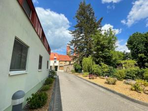 an empty street next to a building with a tree at Akzent Parkhotel Trebbin in Trebbin