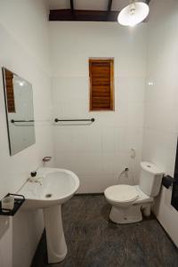 a white bathroom with a toilet and a sink at Mountain Edge By Yala Odyssey in Kataragama +28 photos