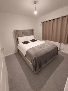 a bedroom with a large bed in a white room at Newly Refurbished 3-Bed Sleeps 5 in Lostock