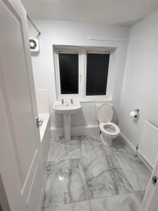 a white bathroom with a toilet and a sink at Newly Refurbished 3-Bed Sleeps 5 in Lostock