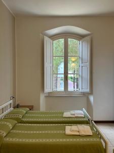 a room with four green beds and a window at San Giuseppe Casa per Ferie in Quercianella