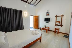 a bedroom with a bed and a television in it at Mountain Edge By Yala Odyssey in Kataragama