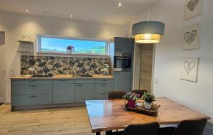 a kitchen with a table and a large window at Gartenbungalow Rhönherz in Hilders