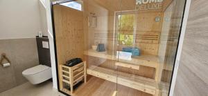 a bathroom with a toilet and a glass shower at Gartenbungalow Rhönherz in Hilders +17 photos