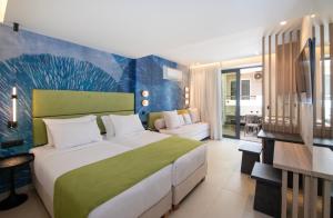 ein Schlafzimmer mit einem großen Bett und einer blauen Wand in der Unterkunft Leonidas Hotel & Apartments in Rethymno + 93 Fotos
