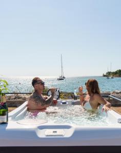 a man and a woman sitting in a bath tub at Pearl Infinity Luxury Floating House in Novigrad Istria