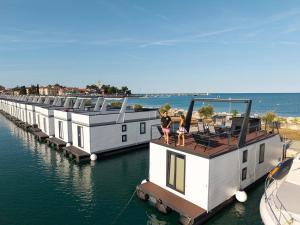a row of houses on a dock in the water at Pearl Infinity Luxury Floating House in Novigrad Istria