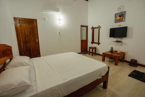 a bedroom with a bed and a flat screen tv at Mountain Edge By Yala Odyssey in Kataragama