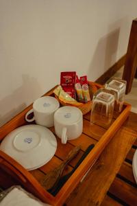 a wooden table with three plates and glasses on it at Mountain Edge By Yala Odyssey in Kataragama