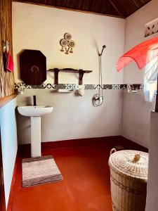a bathroom with a sink and a shelf with a towel at Mahanoro Hotel & Restaurant in Sainte Marie