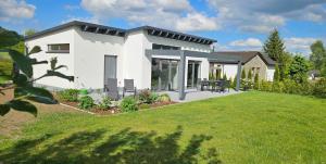 a white house with a lawn in front of it at Gartenbungalow Rhönherz in Hilders