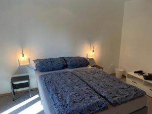 a bedroom with a bed with two lights on the wall at promedklinik apartment 4 in Volkach +10 photos