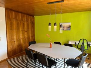 a dining room with a white table and chairs at promedklinik apartment 4 in Volkach