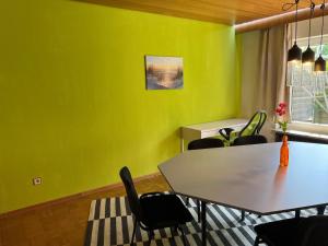 a dining room with green walls and a table and chairs at promedklinik apartment 4 in Volkach