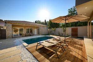 a backyard with a swimming pool and an umbrella at Villa Idola Dassia Corfu in Dassia