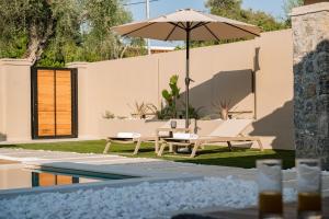 a patio with an umbrella and a pool at Villa Idola Dassia Corfu in Dassia
