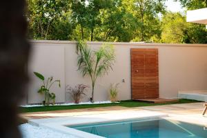 a house with a swimming pool and a wooden door at Villa Idola Dassia Corfu in Dassia