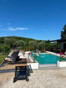 a swimming pool with a bench and a table at Villa Kroi i Vashes in Peqin