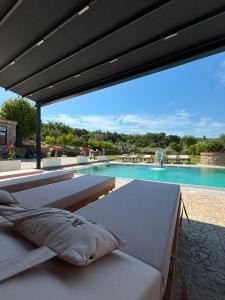a pool with a bed and a swimming pool at Villa Kroi i Vashes in Peqin