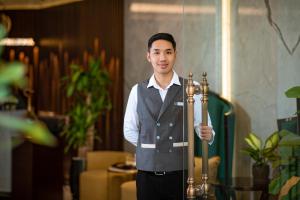 a man is holding a pole in a room at Soleil Boutique Hotel Hanoi in Hanoi