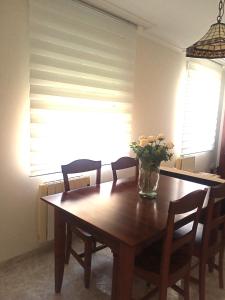 a dining room table with a vase of flowers on it at Casa de Concha in Burela de Cabo +2 photos
