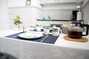 a kitchen counter with a table with cups and a tea kettle at Kerkovernachting in Schettens