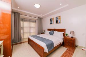 a bedroom with a large bed and a window at Highlands Suites Hotel and Apartments in Kigali