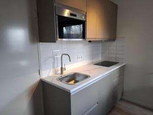 a kitchen with a sink and a microwave at Stad & Strand in Middelburg +10 photos