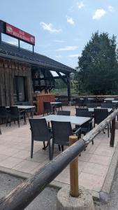 a group of tables and chairs in front of a building at L'auberge des Érables in La Pesse