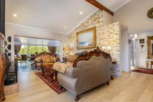 a living room filled with furniture and a stone wall at 17 On Cedar Boutique Guesthouse in Durbanville