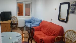 a living room with a blue couch and a table at Apartamentos Salamanca Plaza Del Oeste 3 y 4 dormitorios, 2 baños , Parking in Salamanca