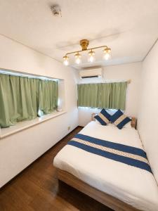 a bedroom with a bed and a window at Atagohama seaside House in Fukuoka