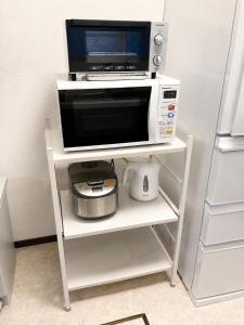 a microwave sitting on a shelf with a toaster oven at Atagohama seaside House in Fukuoka