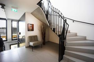 eine Treppe in einem Haus mit einem Stuhl in der Unterkunft Brera Serviced Apartments Munich Schwabing in München