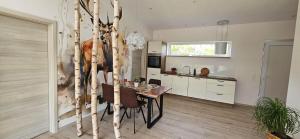 a kitchen and dining room with a table and trees at Gartenbungalow Rhönwild in Hilders +14 photos