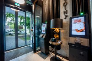 ein Zimmer mit Fernseher, Lampe und Fenster in der Unterkunft Brera Serviced Apartments Munich Schwabing in München