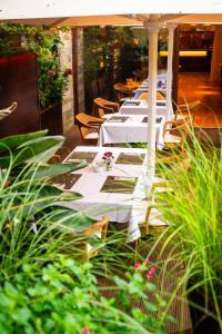 a row of tables with white tablecloths and flowers at Hotel Jaizkibel in Hondarribia