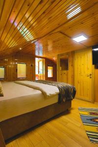 a bedroom with a large bed in a wooden room at İSKALİTA Otel in Altındere