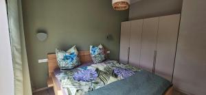 a bedroom with a bed with pillows on it at Gartenbungalow Rhönwild in Hilders