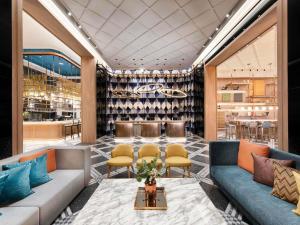 a lobby with couches and chairs and a bar at Mercure Bangkok Sukhumvit 24 in Bangkok